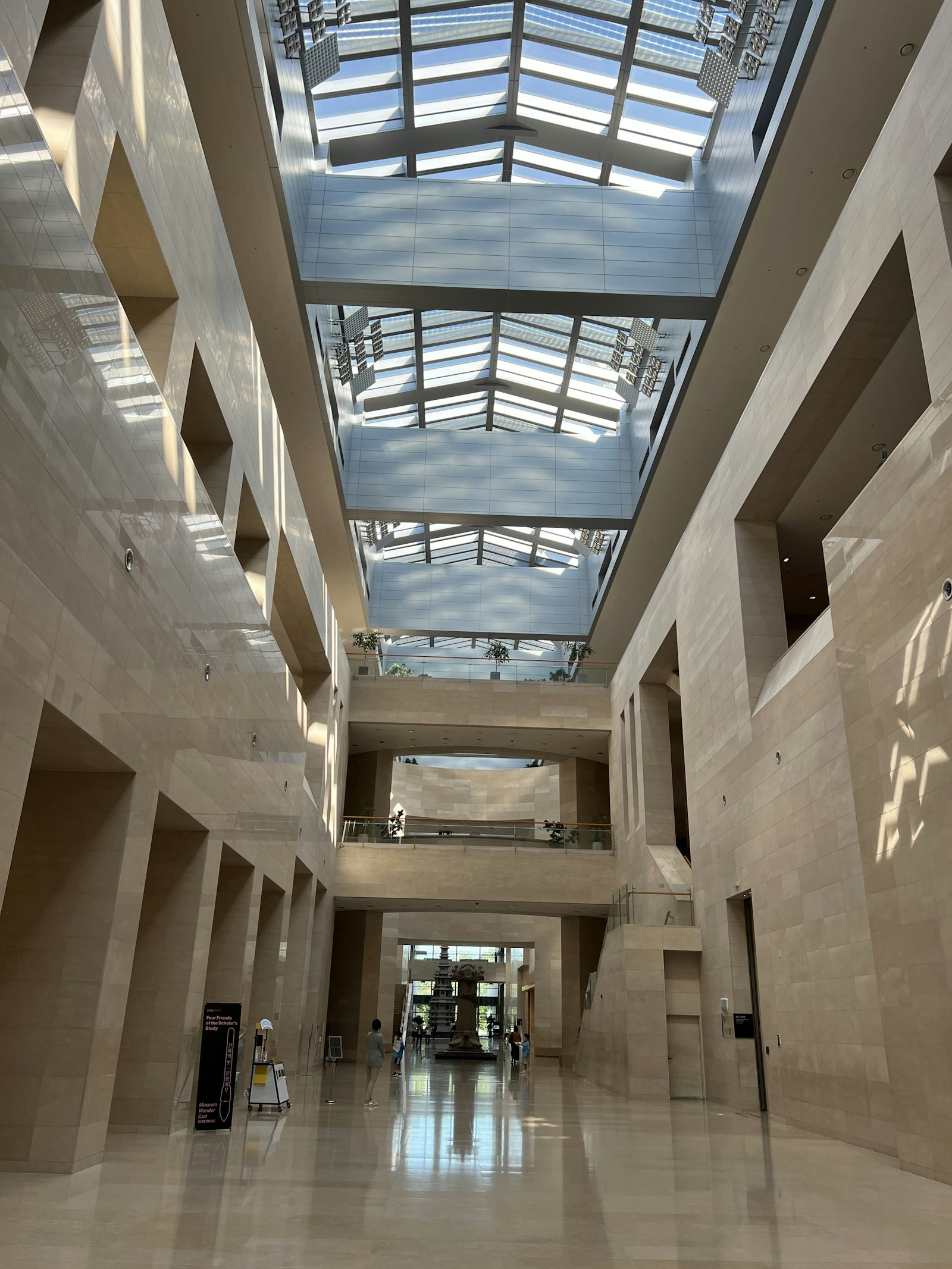 Bright modern building atrium with stone walls and a glass skylight roof