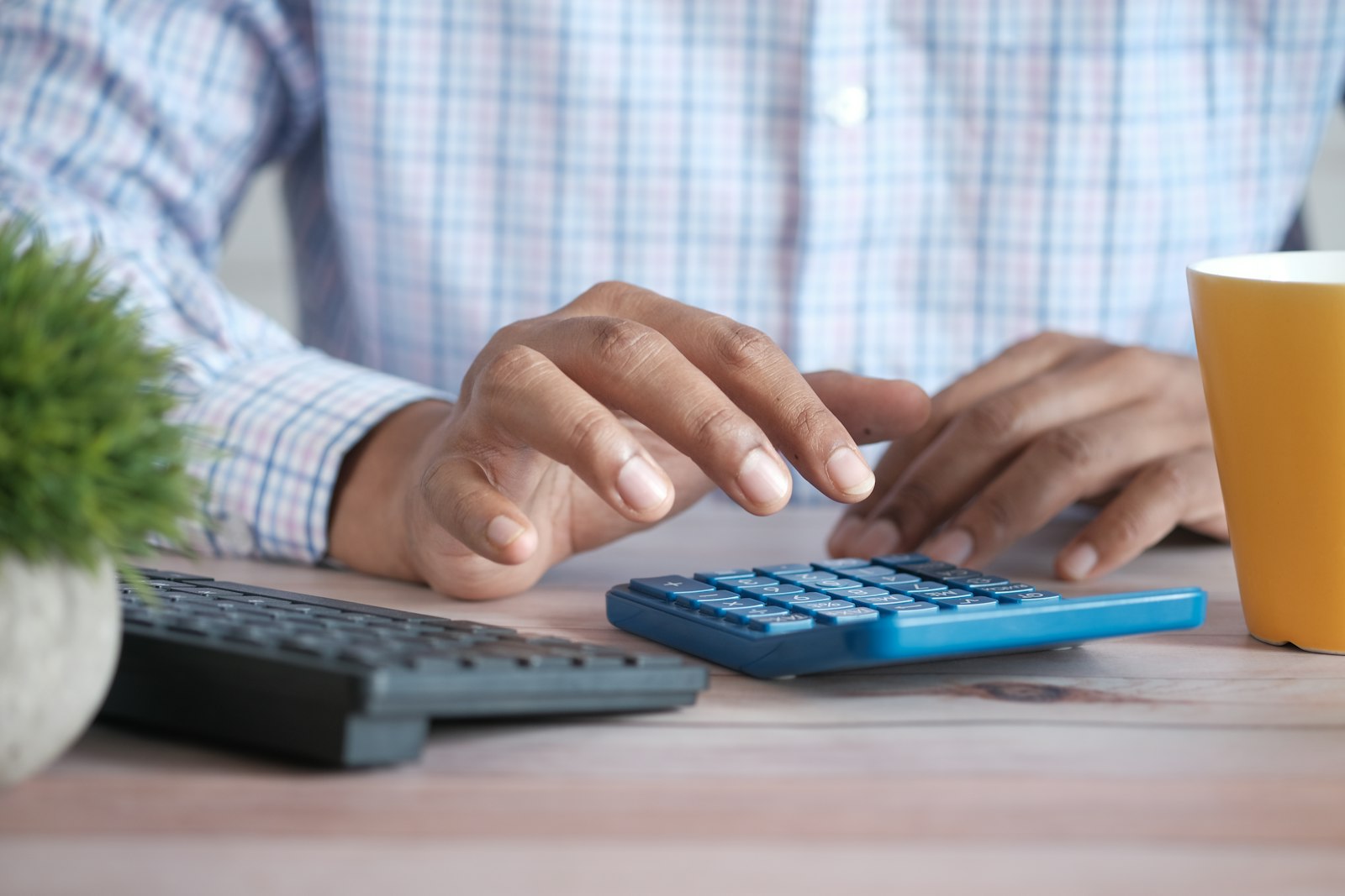 Hands working through figures on a calculator at a desk